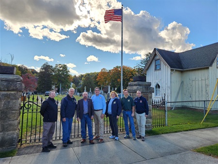 At the entrance to the Orchard Street Cemetery, the Gatehouse is on the left. (l-r) Joe Barilla, Director of the Morris County Office of Planning and Preservation, Keith Titus, Vice President of the Orchard Street Gatehouse Historical Association, Dover Mayor James Dodd, Commissioner Deputy Director Stephen Shaw, Barbara Wood, Paul Wood, Gatehouse Historical Association Recording Secretary and Historian, and Commissioner Tayfun Selen.