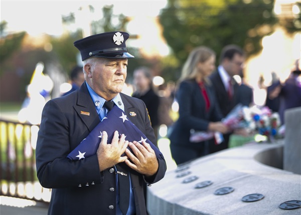 Keynote speaker Rudy Sanfilippo, retired FDNY firefighter, carries the flag to Morris County 9/11 Memorial.