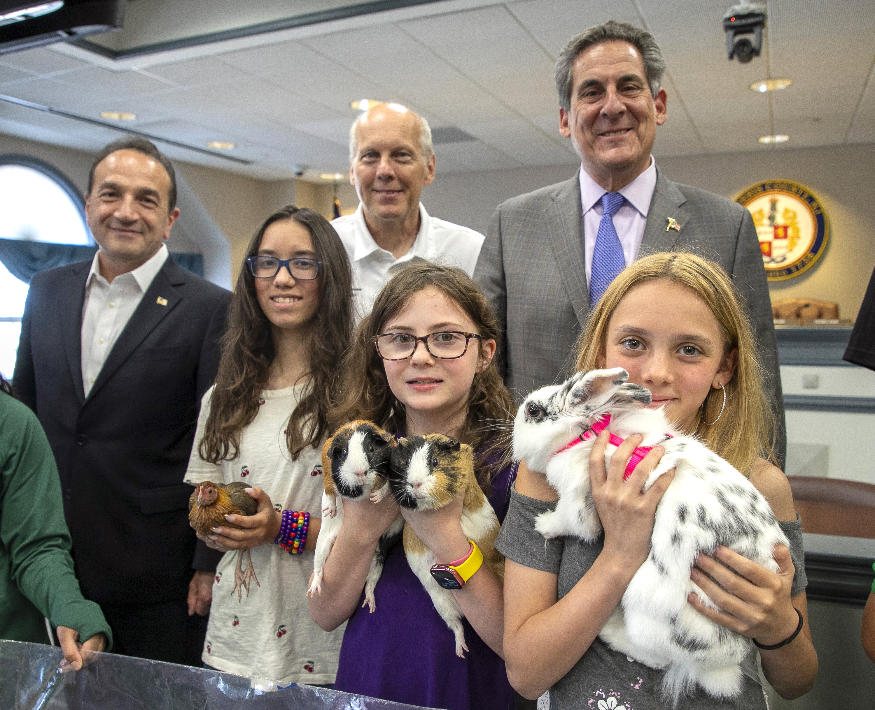 (l-r) Morris County 4-H members Gwennevierre Maury (cq) with a Bantam chicken; Samantha McCardle with her guinea pigs Brownie and Nugget; and Khloe Terrazas with her lionhead bunny Luna. Back row, left to right, are Morris County Commissioners Tayfun Selen, Commissioner Deputy Director John Krickus and Commissioner Director Stephen H. Shaw.