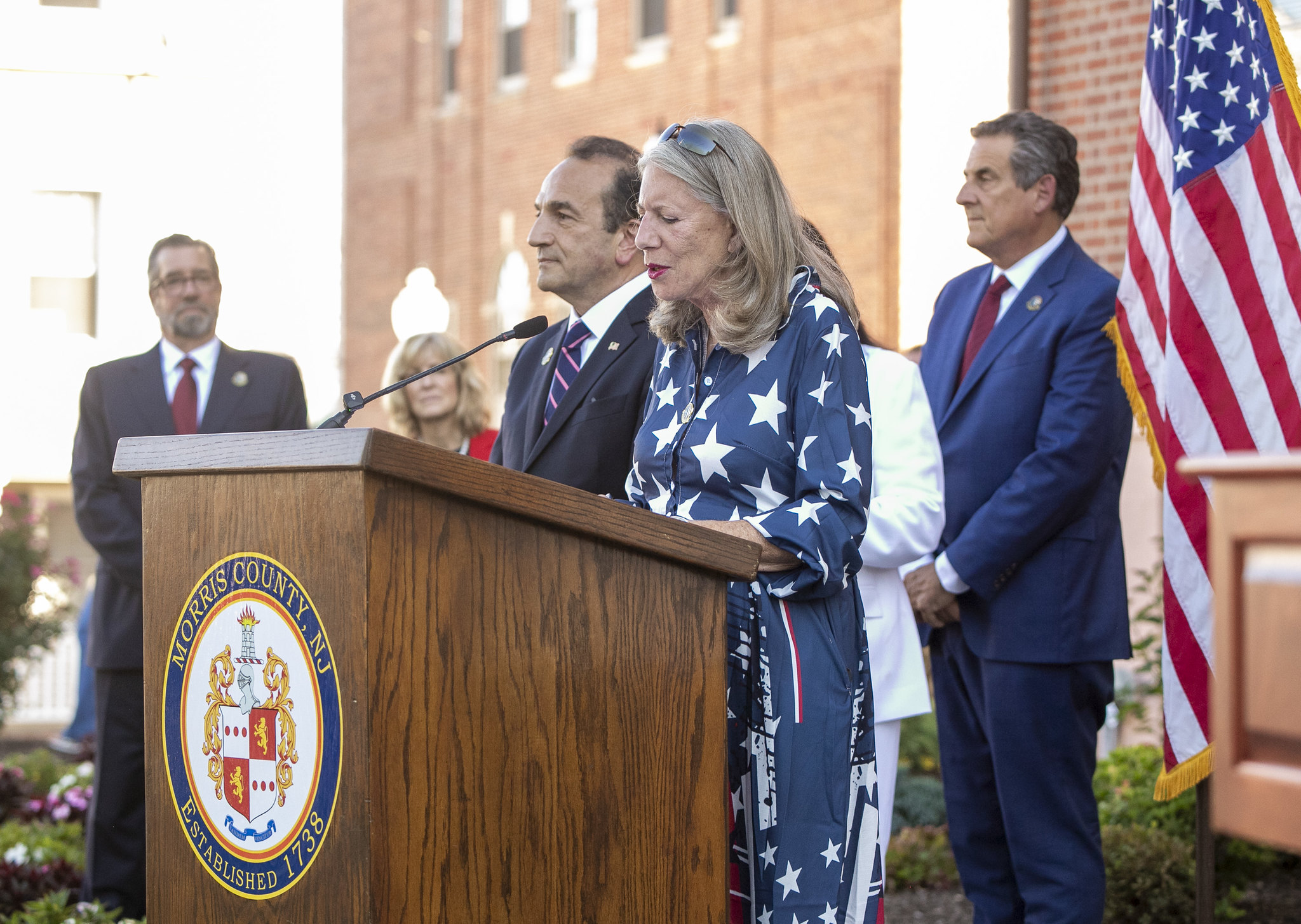 Commissioner Deborah Smith reads a portion of the Declaration of Independence. At left is Commissioner Tayfun Selen and Director Shaw is standing behind them. In the background is Assistant County Administrator Brian Murray (left) and Commissioner Christine Myers.