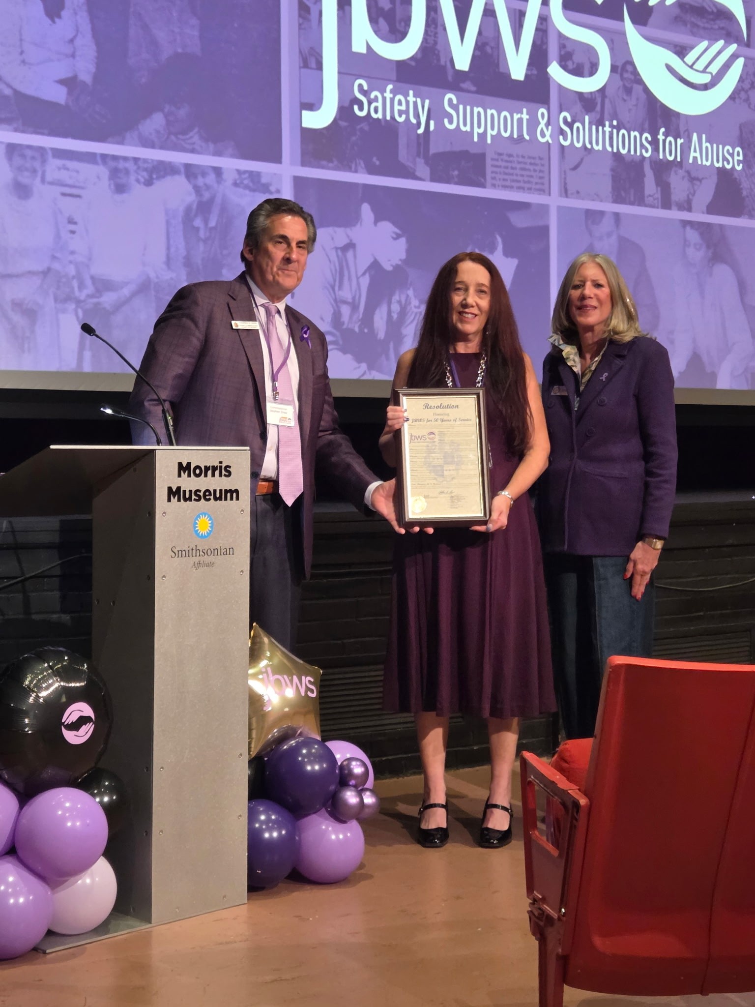 Commissioner Director Stephen H. Shaw presents a Morris County Resolution of Honor to JBWS President and CEO Diane Williams with Commissioner Debra Smith.