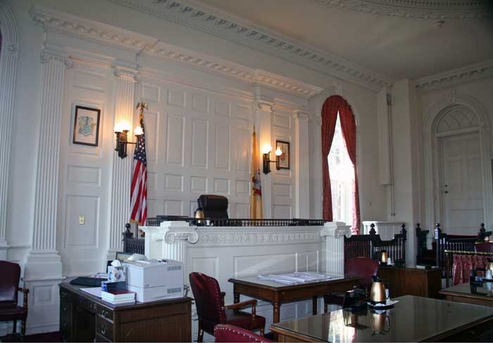 Courtroom #1's judge bench. The room is white with wainscoting