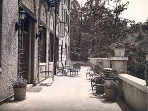 The rear of the building, with tables, chairs and flowerpots