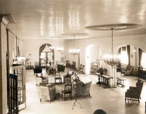 Lobby reading room, with chairs, tables, chandeliers hanging from ceiling medallions