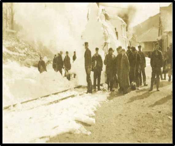 Railroad workers in the snow, shoveling out a locomotive