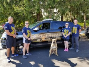 Morris County Sheriff's Office Sergeant John Rospond, Investigator Ashley Craig, K-9 Kai, Sheriff's Chief Kelley Zienowicz and Detective Corporal Mike McMahon prepare to run their leg of the Law Enforcement Torch Run for Special Olympics NJ on October 9, 2020.