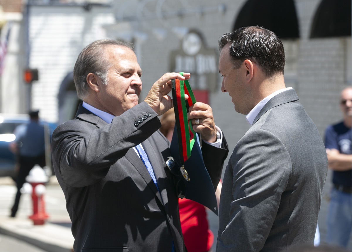 Commissioner Mastrangelo presents a medal to Infusino