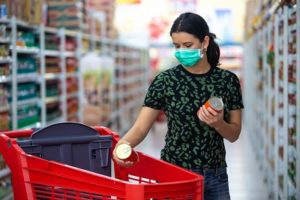 woman wearing face covering does grocery shopping