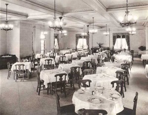 Dining room, with round tables with 4 chairs each and chandeliers