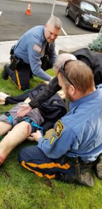 Morris County Sheriff's Officer Greg Lukaszyk and Sheriff's Office Corporal Max Englert practice life-saving bleeding control measures on a mannequin outside the Morris County courthouse.