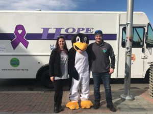 A peer recovery specialist and Morris County Sheriff's Officer with a penquin mascot in Asbury Park