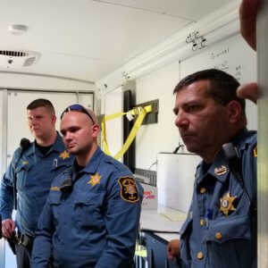From left, Morris County Sheriff's Officers Frank Pirog and Travis Somerville, with Sheriff's Office Sergeant John Rospond, discuss strategy in a mobile command vehicle during a training exercise to find a fictitious lost hiker at Mahlon Dickerson Reservation in Jefferson Township. 