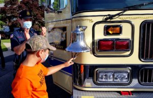 Nesim Aktas, 9, of Boonton, rings the firetruck bell to mark his completion of chemotherapy to treat leukemia.