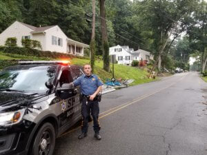 Morris County Sheriff's Officer Joe McGee secured a section of road in Randolph Township after Tropical Storm Isaias damaged power lines, including one leaning in the background. 