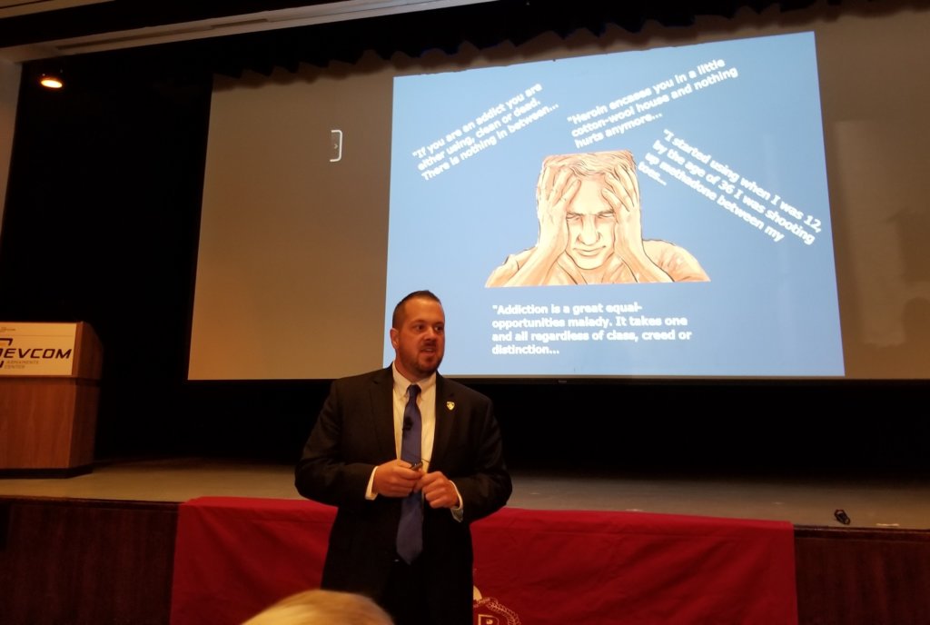 Seabury presenting in front of a projection screen