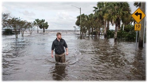 Man walking through the water on a flooded street