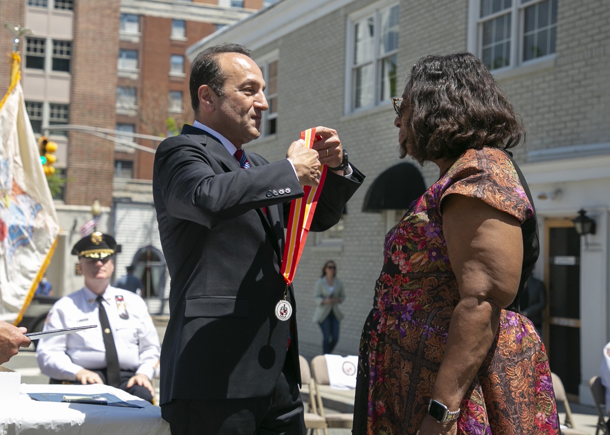 Commissioner Selen presents a medal to Jones