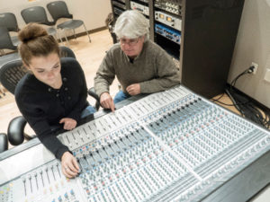 photo of a student and professor at a sound board