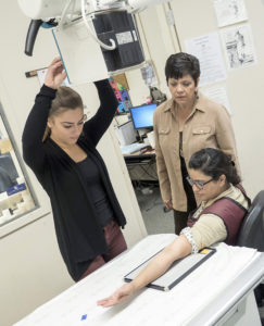 A student practices using equipment during radiography training.