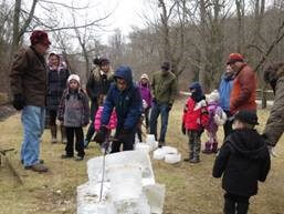 Children learn how to cut a block of ice