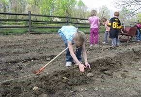 Chilren plant seeds in a tilled field