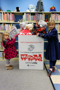Photo: Hanover residents Daphne and Margot use the Toys for Tots bin located in the Children's Room of the Whippanong Library to donate a tea set and fire truck during the 2017 collection.