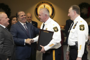 Capt. Janzen (left) and Capt. McCaffrey accept congratulations from Freeholder Tom Mastrangelo during event
