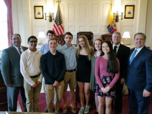 Photo shows Bar Foundation Present Joseph Cadicina (far left) and Freeholder Tom Mastrangelo (far right) pose with coach Eric Heditsch and the West Morris Mendham High School mock trial team 