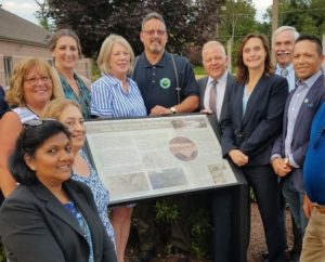 Freeholders and engineering staff in front of historic plaque