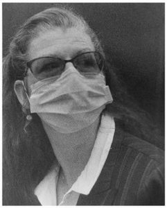 Black and white photo of a woman wearing a mask
