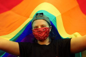 rainbow material around a person in a mask